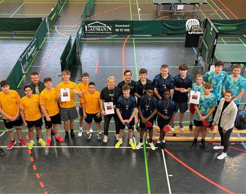 Foto der Schüler in der Sporthalle vor aufgestelltem Tischtennisequipment