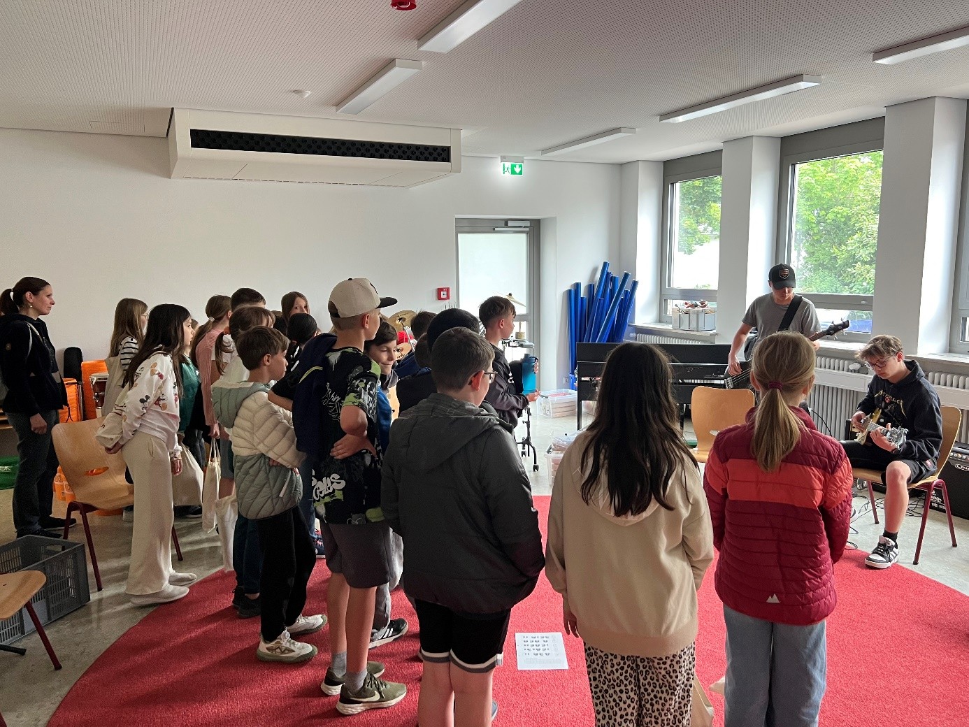 Bild von Schülern der 9. Klassen, die Bass und Gitarre für die Grundschüler spielen