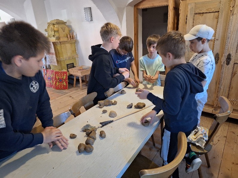 Foto der 5. Klasse beim Erkunden von jungsteinzeitlichem Werkzeug.